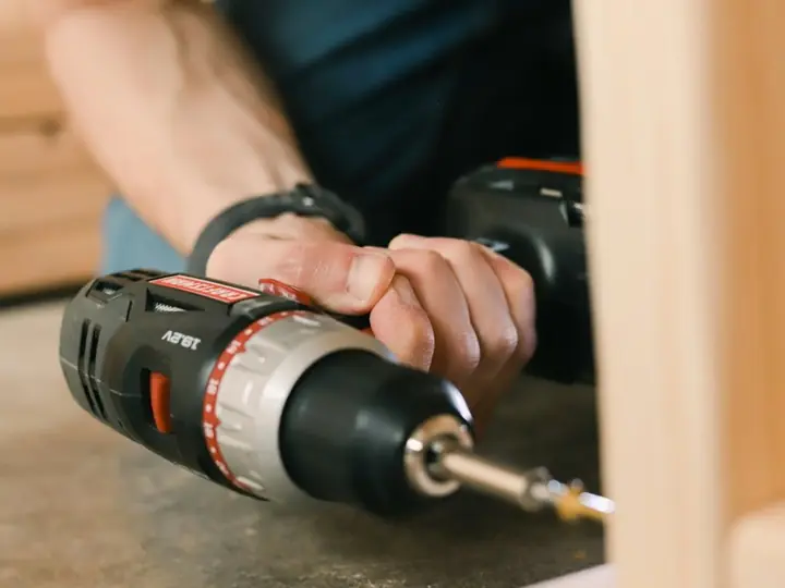 A hand holding a power drill