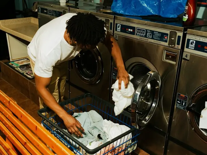 A man loading clothes into a washing machine
