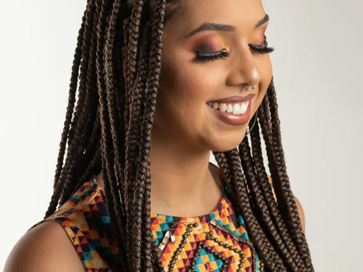 A smiling woman with long braids